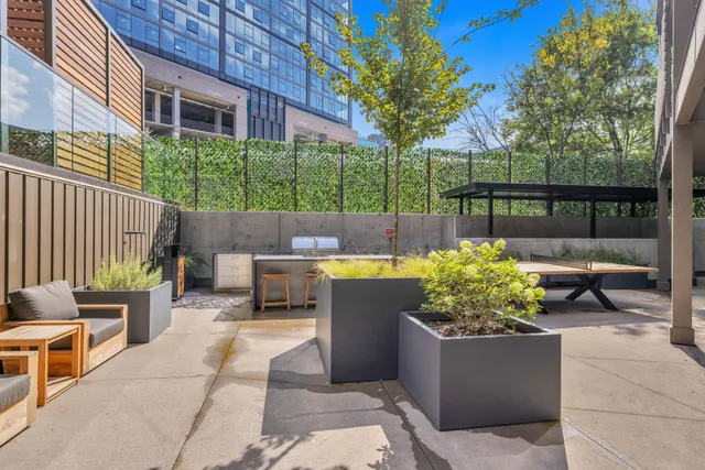 a view of a patio with a table and chairs and potted plants