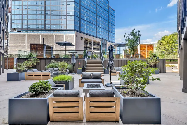 a view of a patio with couches table and chairs and potted plants