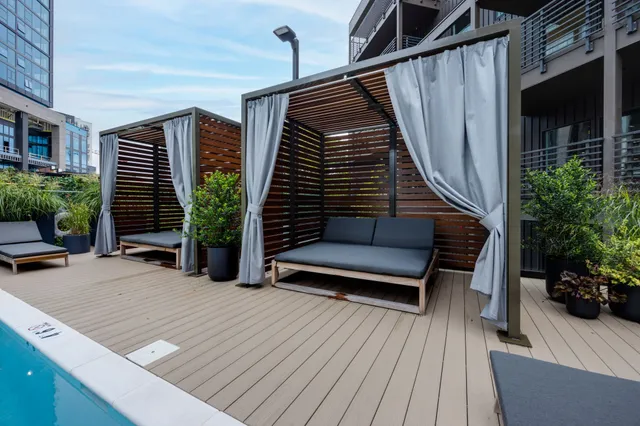 a view of a swimming pool with outdoor seating and plants