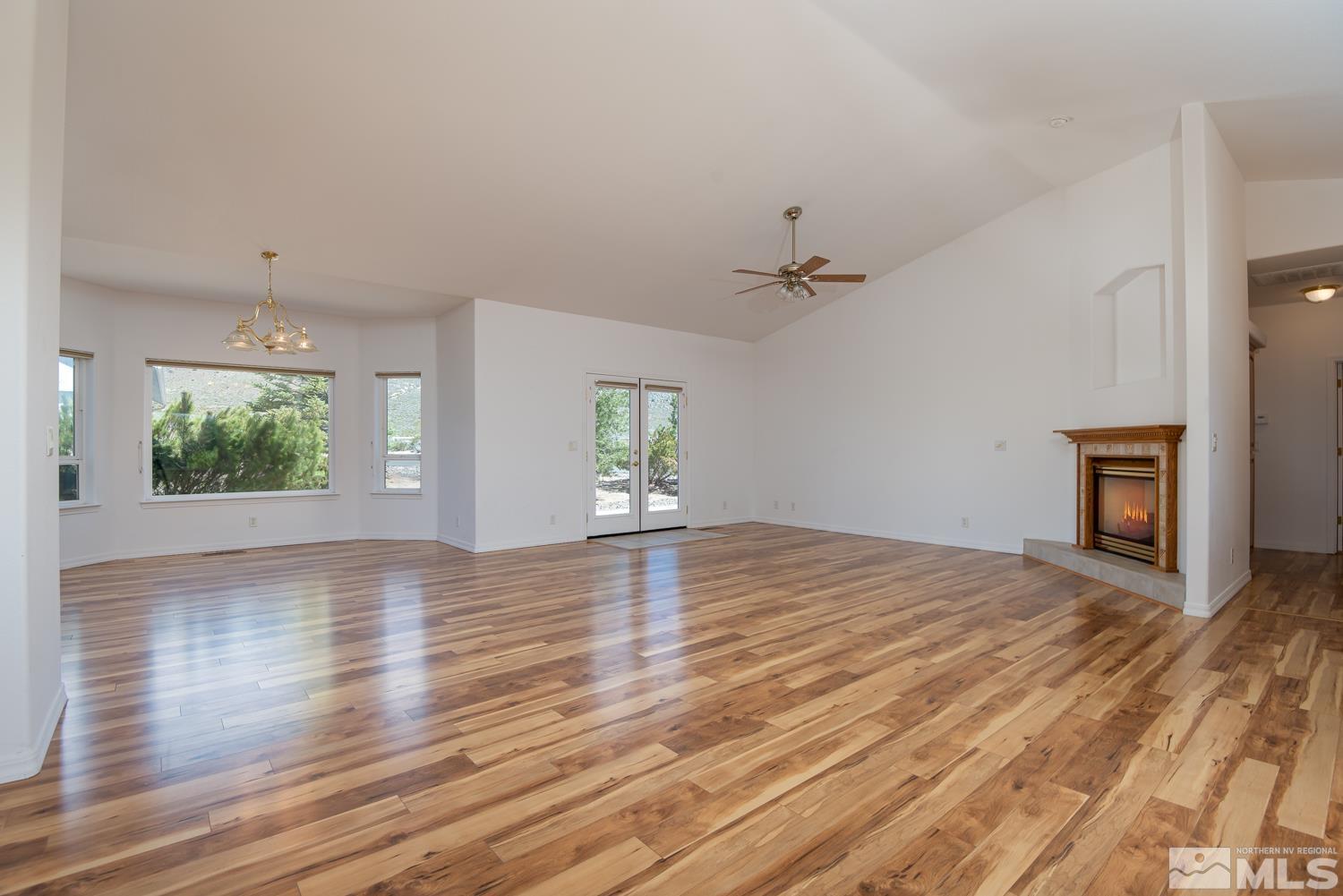 2876 Jackie Circle Minden, NV 89423 - Photo 11 of 40 an empty room with wooden floor fireplace and windows