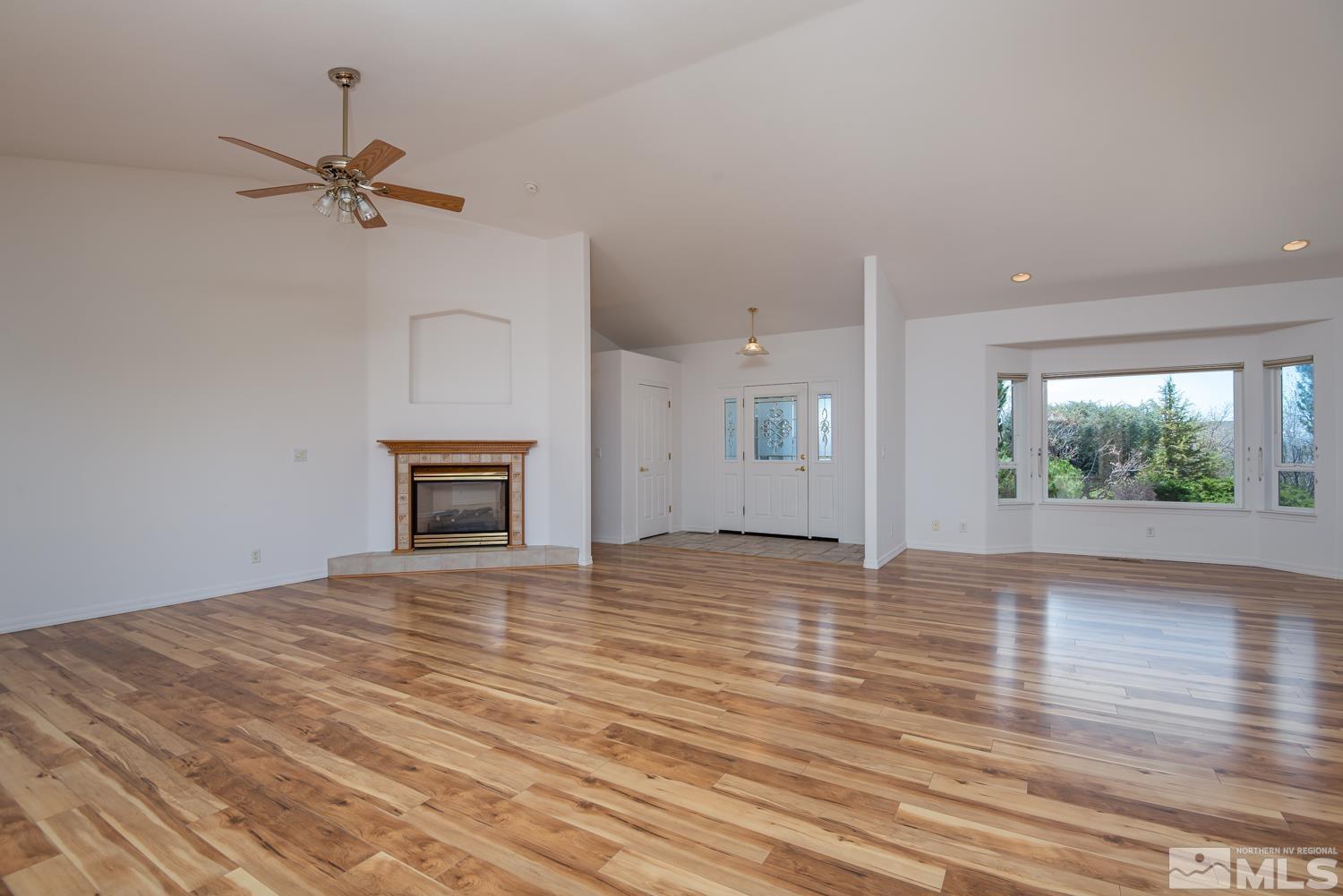 2876 Jackie Circle Minden, NV 89423 - Photo 12 of 40 a view of an empty room with wooden floor and a fireplace