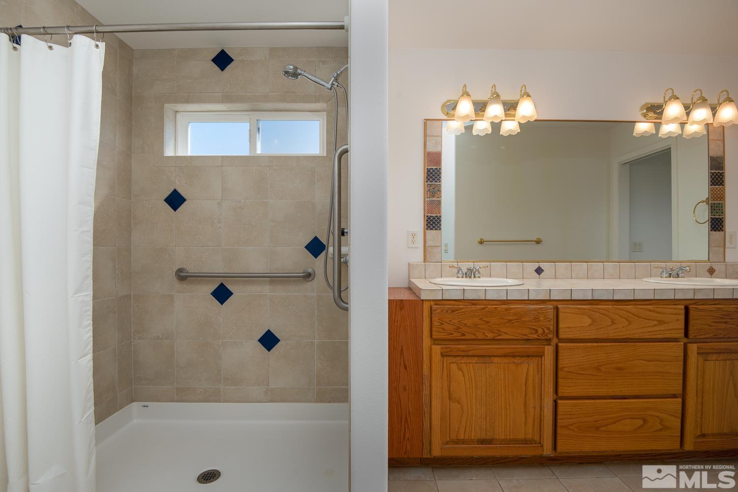 2876 Jackie Circle Minden, NV 89423 - Photo 16 of 40 a bathroom with a sink mirror and a bathtub