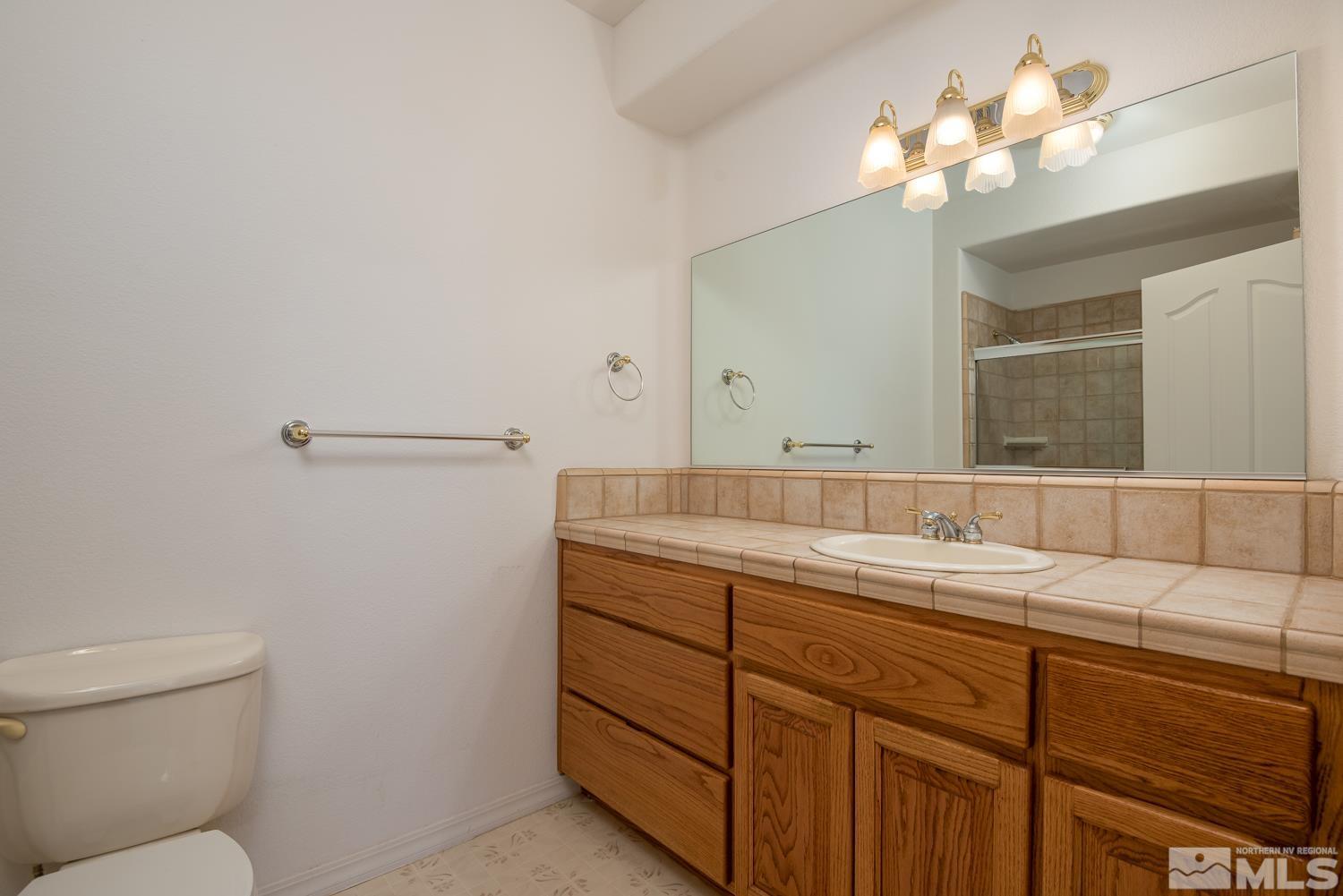 2876 Jackie Circle Minden, NV 89423 - Photo 23 of 40 a bathroom with a toilet sink and mirror