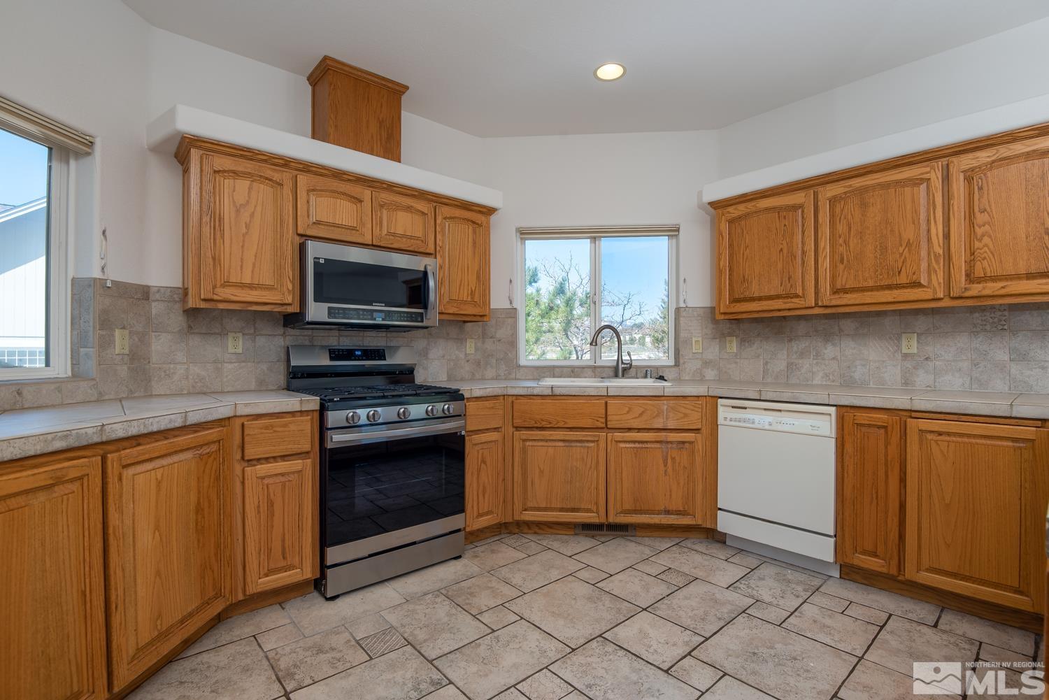2876 Jackie Circle Minden, NV 89423 - Photo 9 of 40 a kitchen with stainless steel appliances granite countertop a stove top oven a sink dishwasher and granite countertops