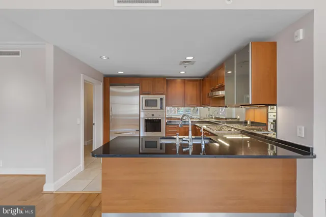 a kitchen with stainless steel appliances granite countertop a refrigerator and a stove top oven