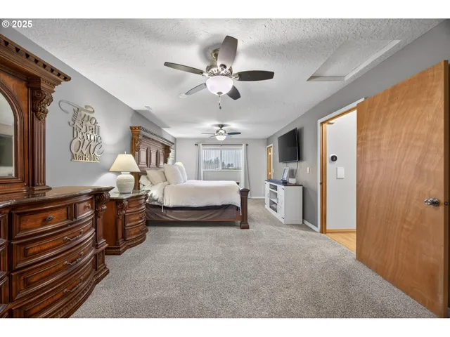 a spacious bedroom with a bed and a chandelier