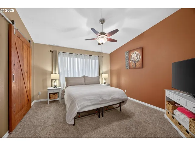 a bedroom with a bed and a flat screen tv