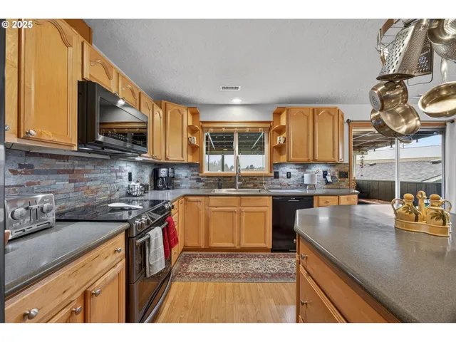 a kitchen with stainless steel appliances granite countertop a sink stove and cabinets