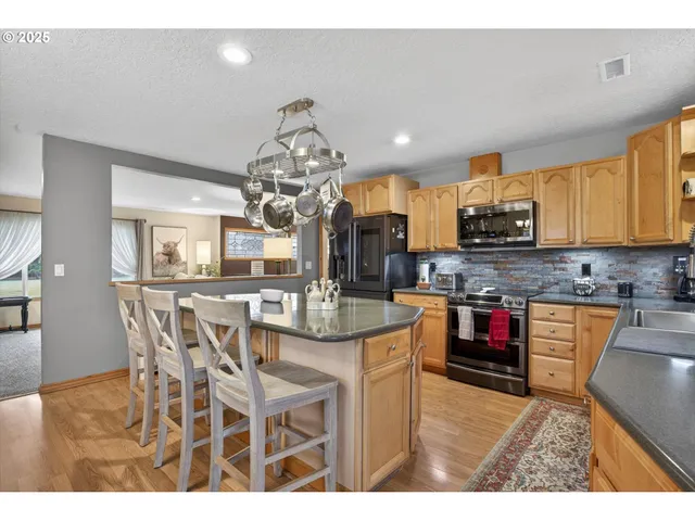a kitchen with stainless steel appliances granite countertop a stove top oven a sink a counter space and cabinets