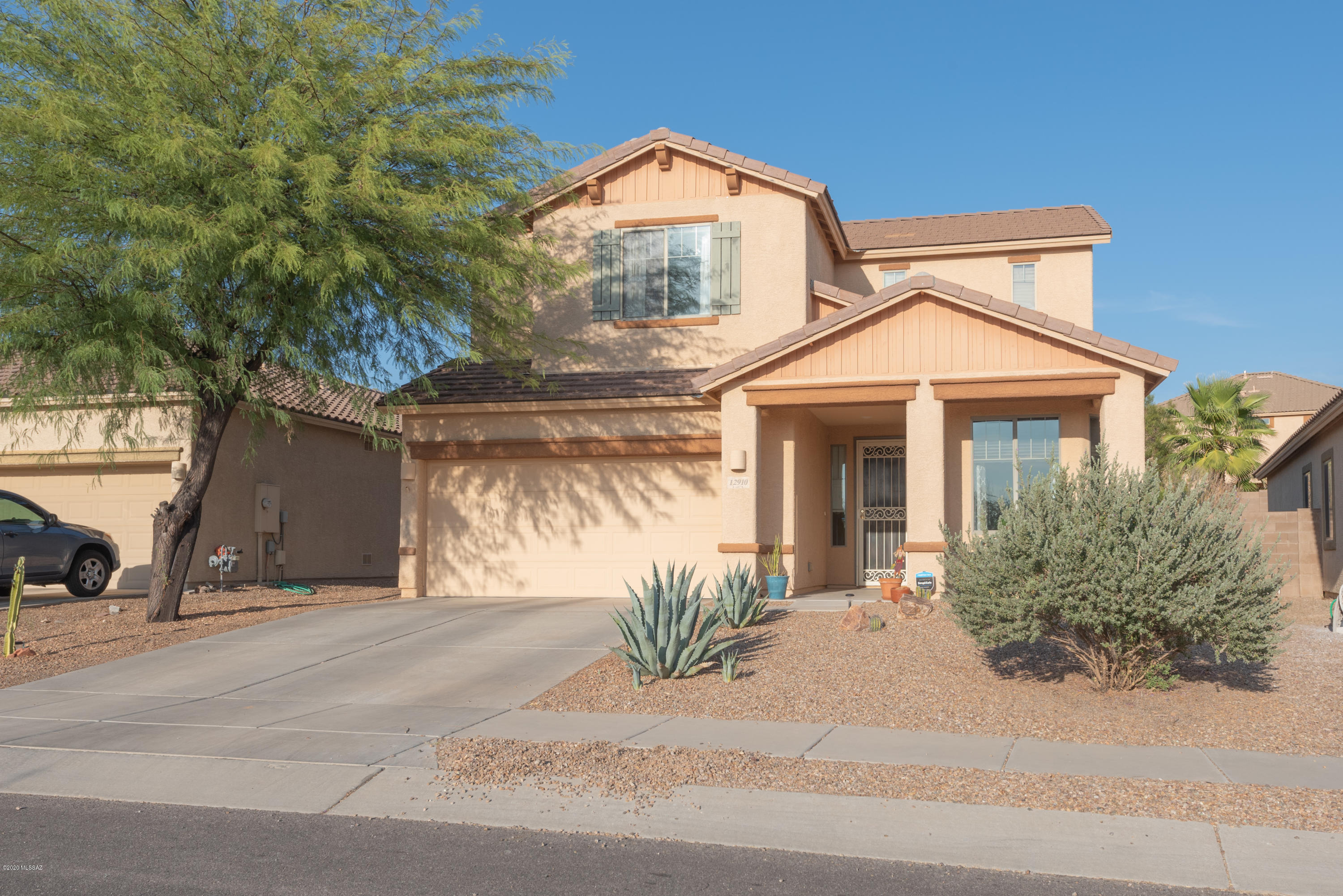 12910 Bloomington Loop Oro Valley, AZ 85755 - Photo 30 of 30 a front view of a house with a yard and potted plants