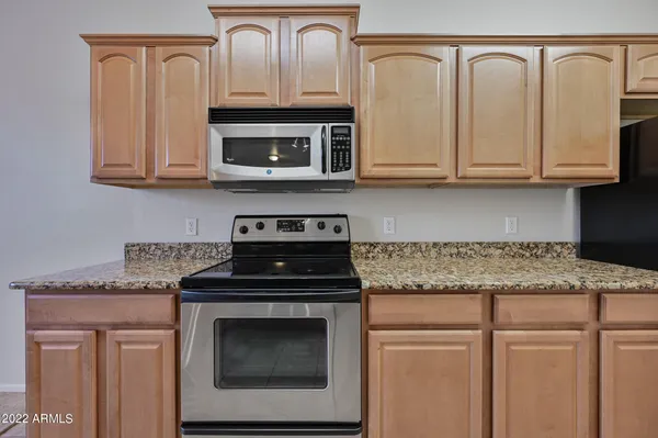 a kitchen with granite countertop white cabinets and a stove top oven