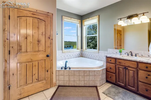 a bathroom with a tub a sink and mirror
