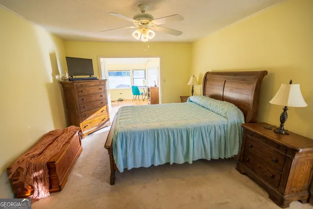 a bedroom with a bed dresser and a flat tv screen