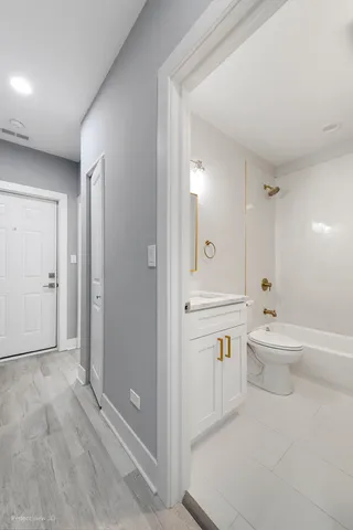 a bathroom with a bathtub shower sink mirror and toilet