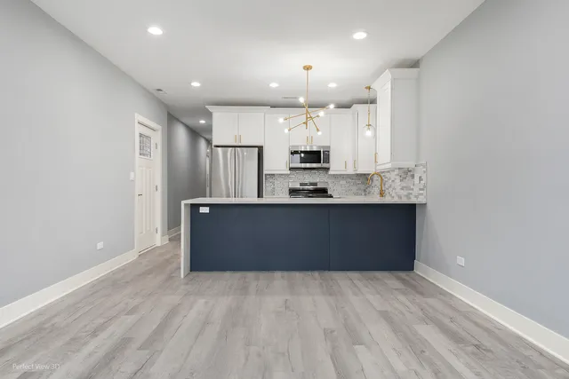 a large kitchen with kitchen island a sink stainless steel appliances and cabinets