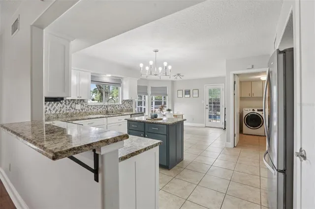 a view of living room kitchen with stainless steel appliances granite countertop cabinets and fireplace