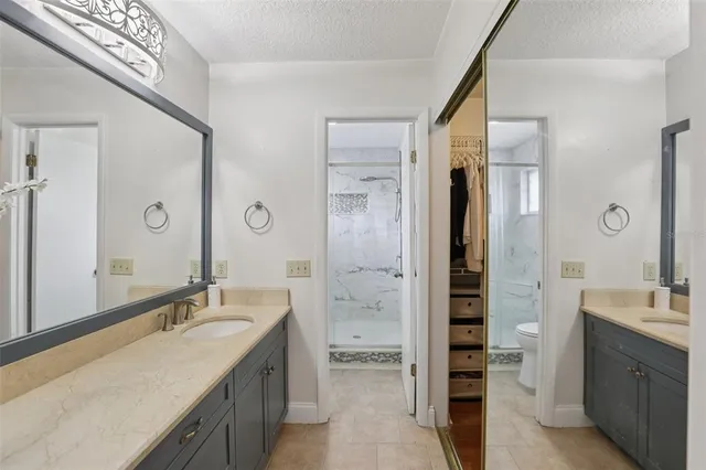 a spacious bathroom with a shower sink and mirror