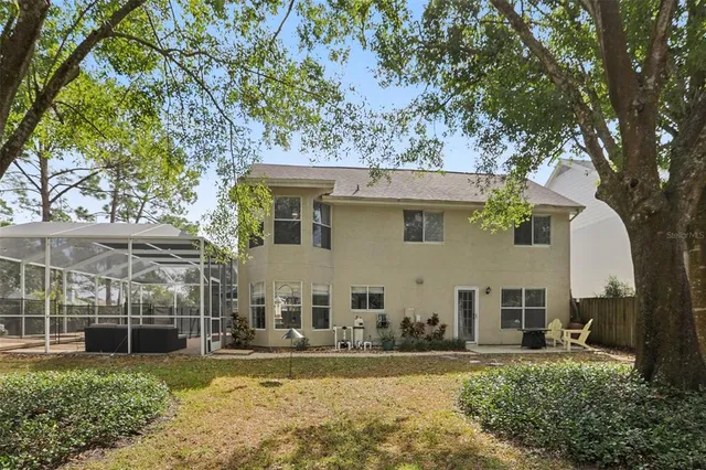 a view of a backyard with wooden fence and large tree