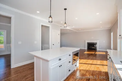 a view of a kitchen with a sink a refrigerator and wooden floor