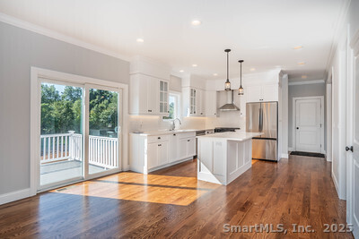 963 High Road Berlin, CT 06037 - Photo 30 of 39 a large white kitchen with kitchen island a large counter space a sink appliances and cabinets