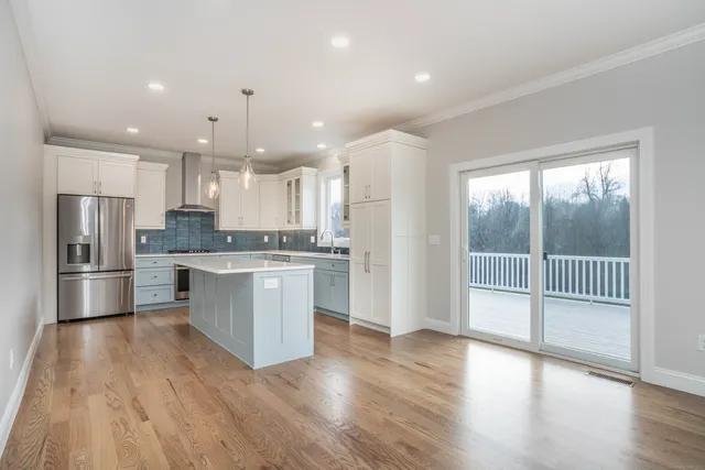 a kitchen with a refrigerator and white cabinets