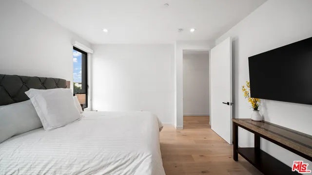 a bedroom with a bed and a flat screen tv