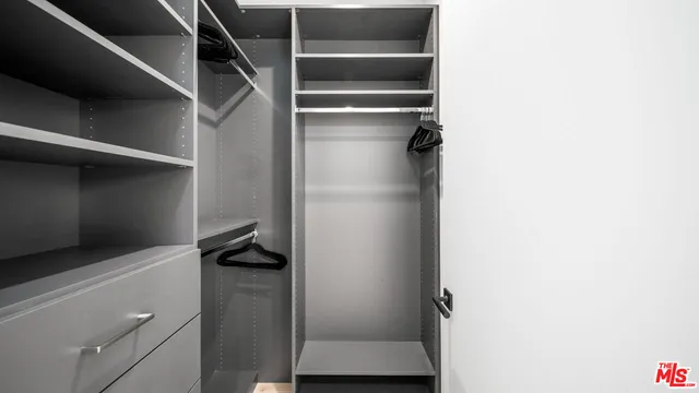 a view of walk in closet with clothes and shoes