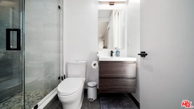 a bathroom with a sink a toilet and shower