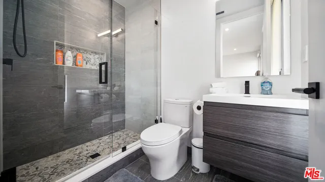 a bathroom with a sink a toilet and shower