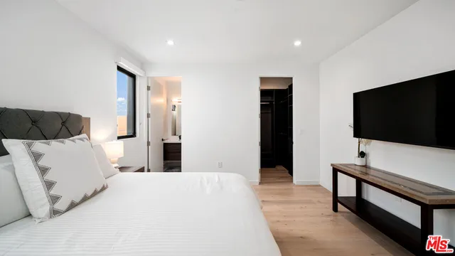 a bedroom with a bed and a flat screen tv