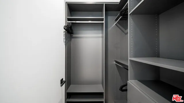 a view of walk in closet with empty racks