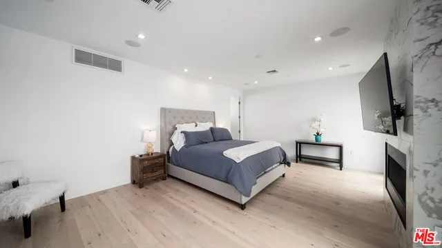 a bedroom with a bed and a flat screen tv