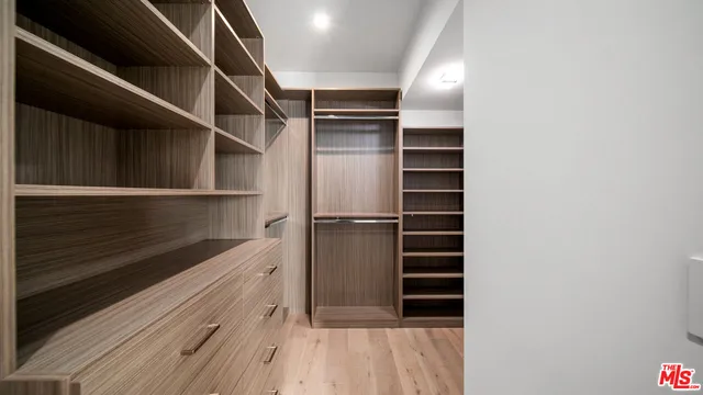 a view of walk in closet with empty racks