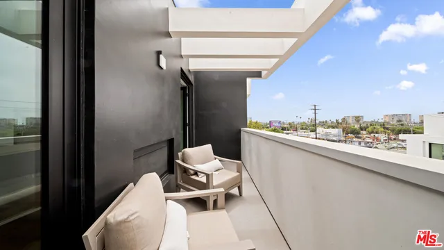 a balcony with chairs and view of a bathroom