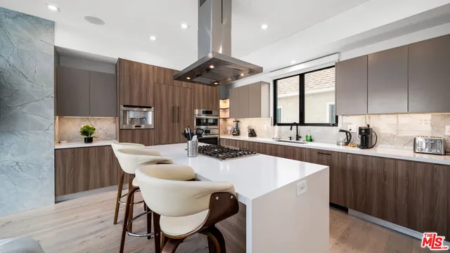 a kitchen with a dining table chairs stainless steel appliances and cabinets
