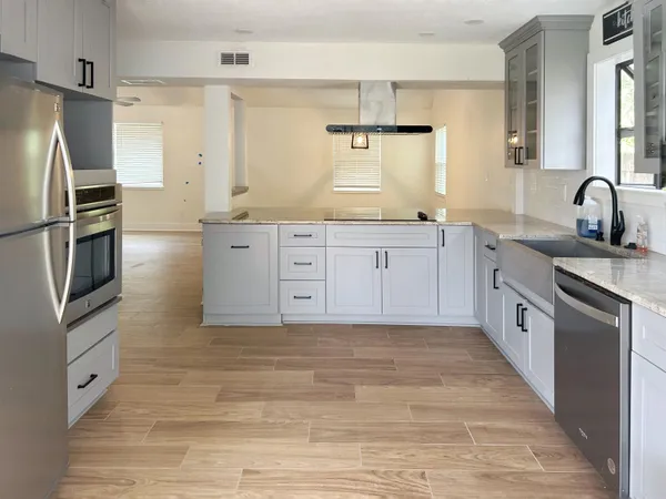 a large kitchen with stainless steel appliances granite countertop a stove and a sink