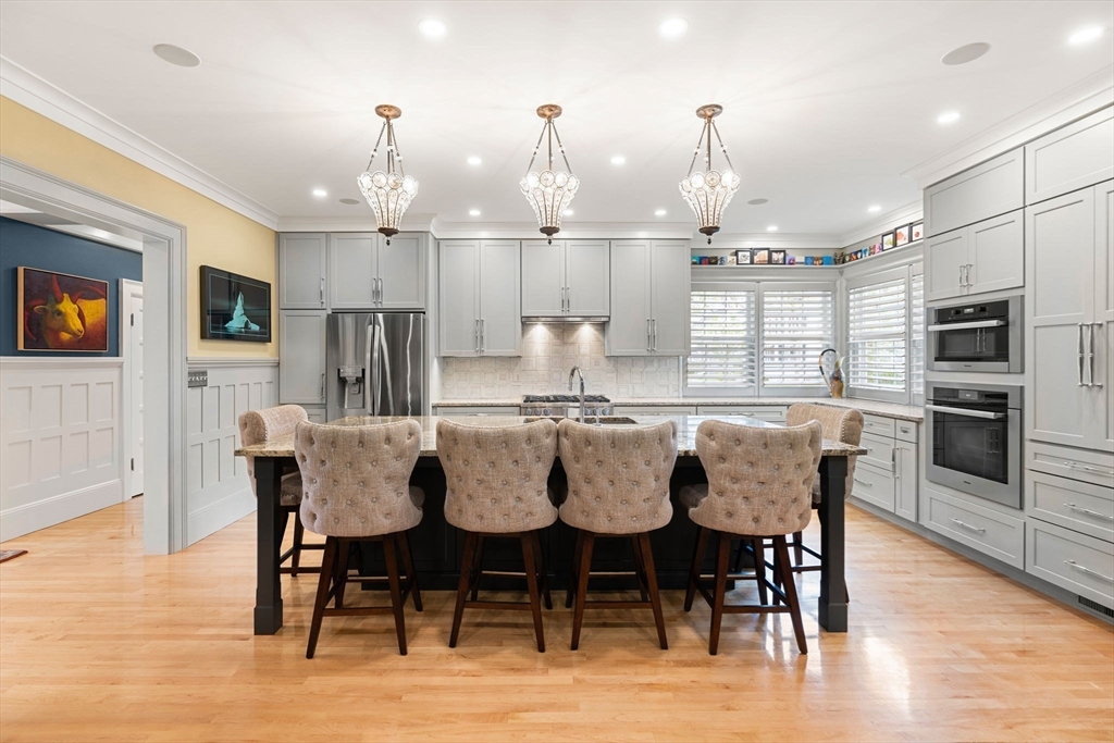 79 Wedge Street Lowell, MA 01851 - Photo 13 of 42 a kitchen with kitchen island granite countertop a dining table chairs stainless steel appliances and cabinets