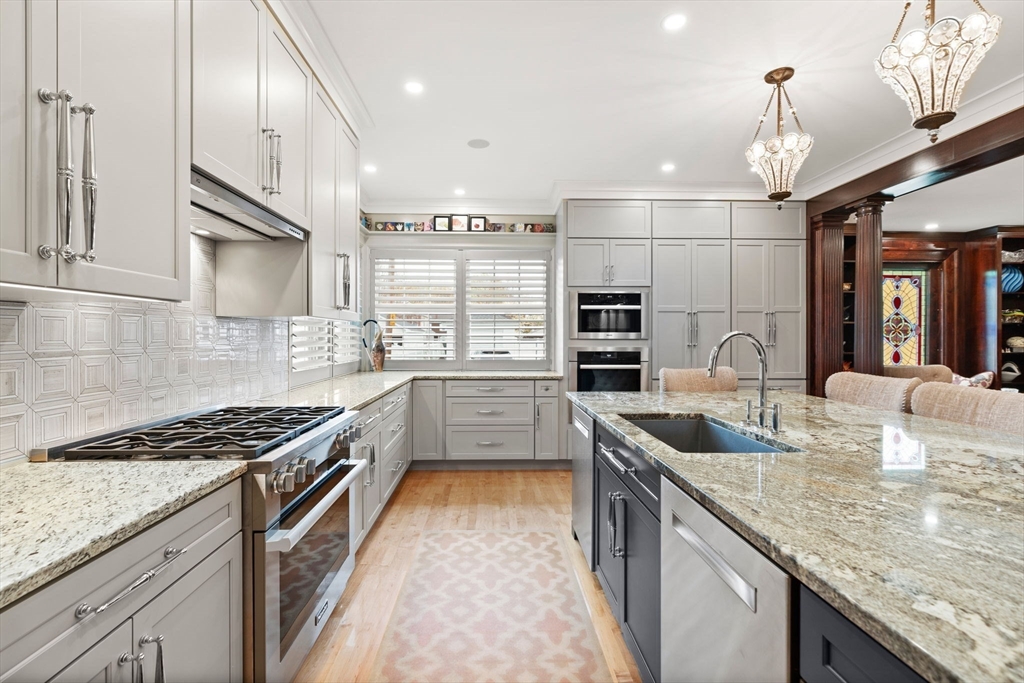 79 Wedge Street Lowell, MA 01851 - Photo 14 of 42 a kitchen with stainless steel appliances granite countertop a sink a stove and kitchen island