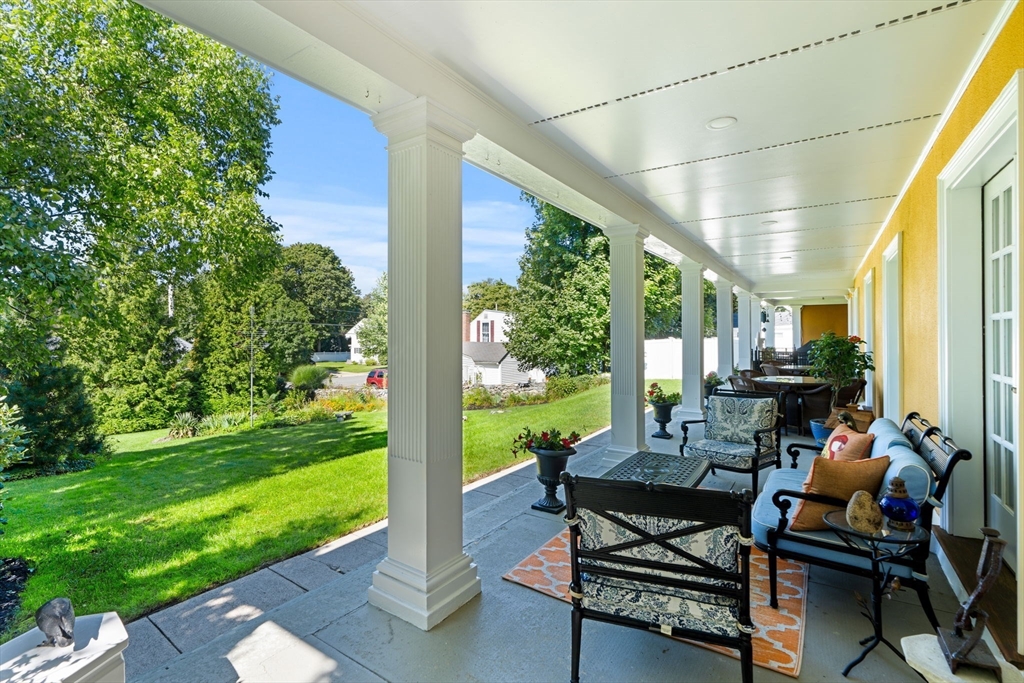 79 Wedge Street Lowell, MA 01851 - Photo 40 of 42 a view of a patio with table and chairs potted plants with wooden floor and fence
