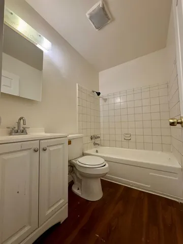 a bathroom with a toilet a sink a mirror and bathtub