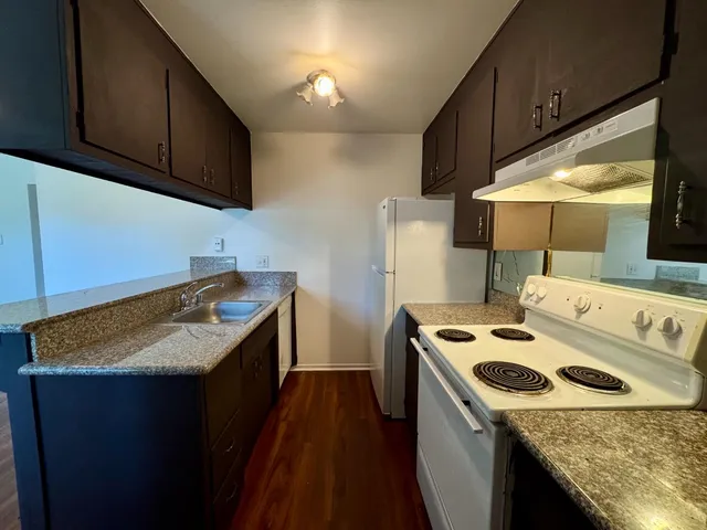 a kitchen with a stove sink and cabinets
