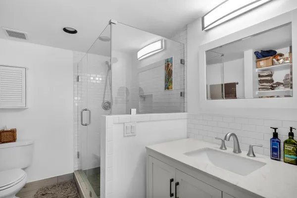 a bathroom with a sink toilet double vanity and shower