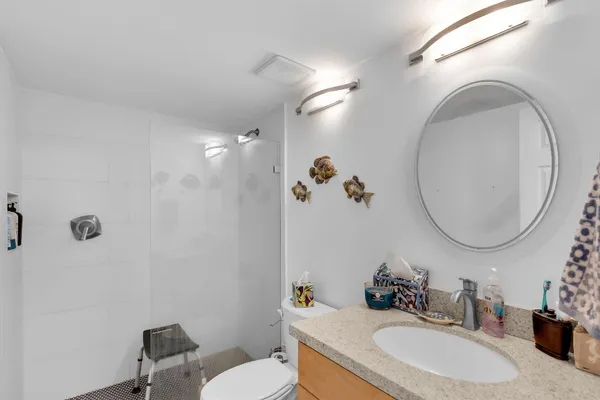 a bathroom with a sink vanity mirror and toilet