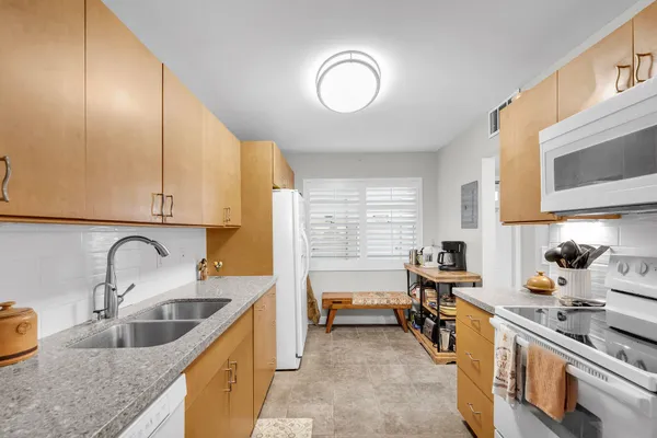a kitchen with stainless steel appliances granite countertop a sink and a stove