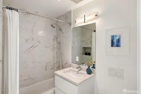 a bathroom with a sink mirror and shower