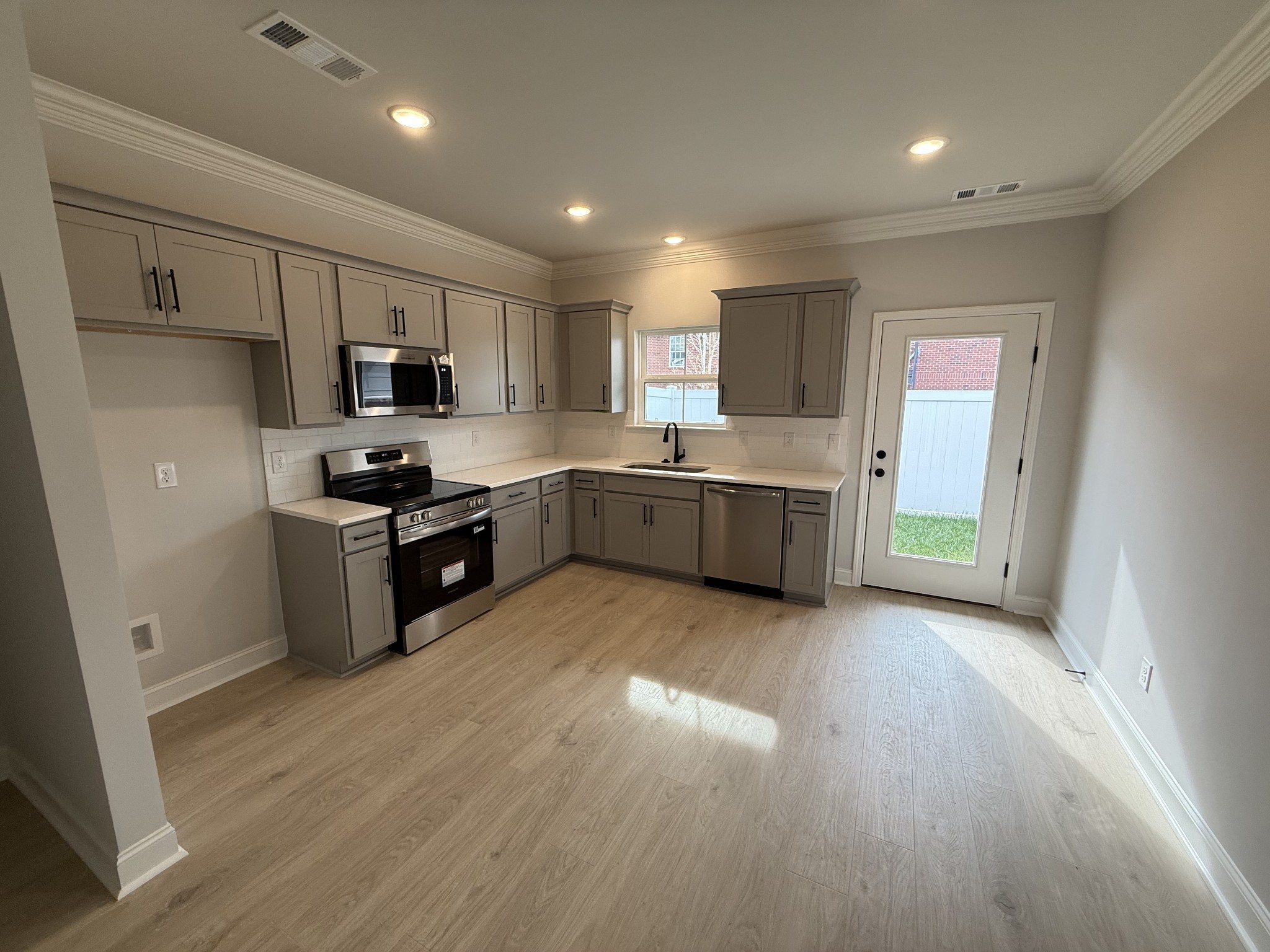 607 Rohan Drive Murfreesboro, TN 37129 - Photo 5 of 24 a kitchen with stainless steel appliances a sink a stove a refrigerator cabinets and a window