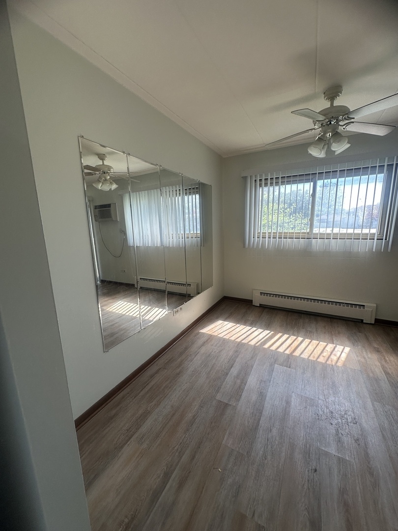 18550 Torrence Avenue, Unit 4 Lansing, IL 60438 - Photo 11 of 14 wooden floor in an empty room with a window