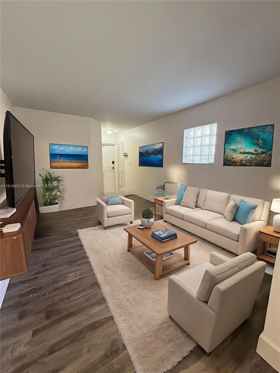 22901 Southwest 88th Place, Unit 101 Cutler Bay, FL 33190 - Photo 2 of 16 a living room with furniture flat screen tv and wooden floor