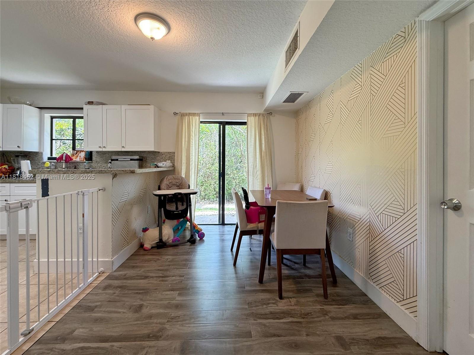 22901 Southwest 88th Place, Unit 101 Cutler Bay, FL 33190 - Photo 4 of 16 a dining room with furniture and a wooden floor