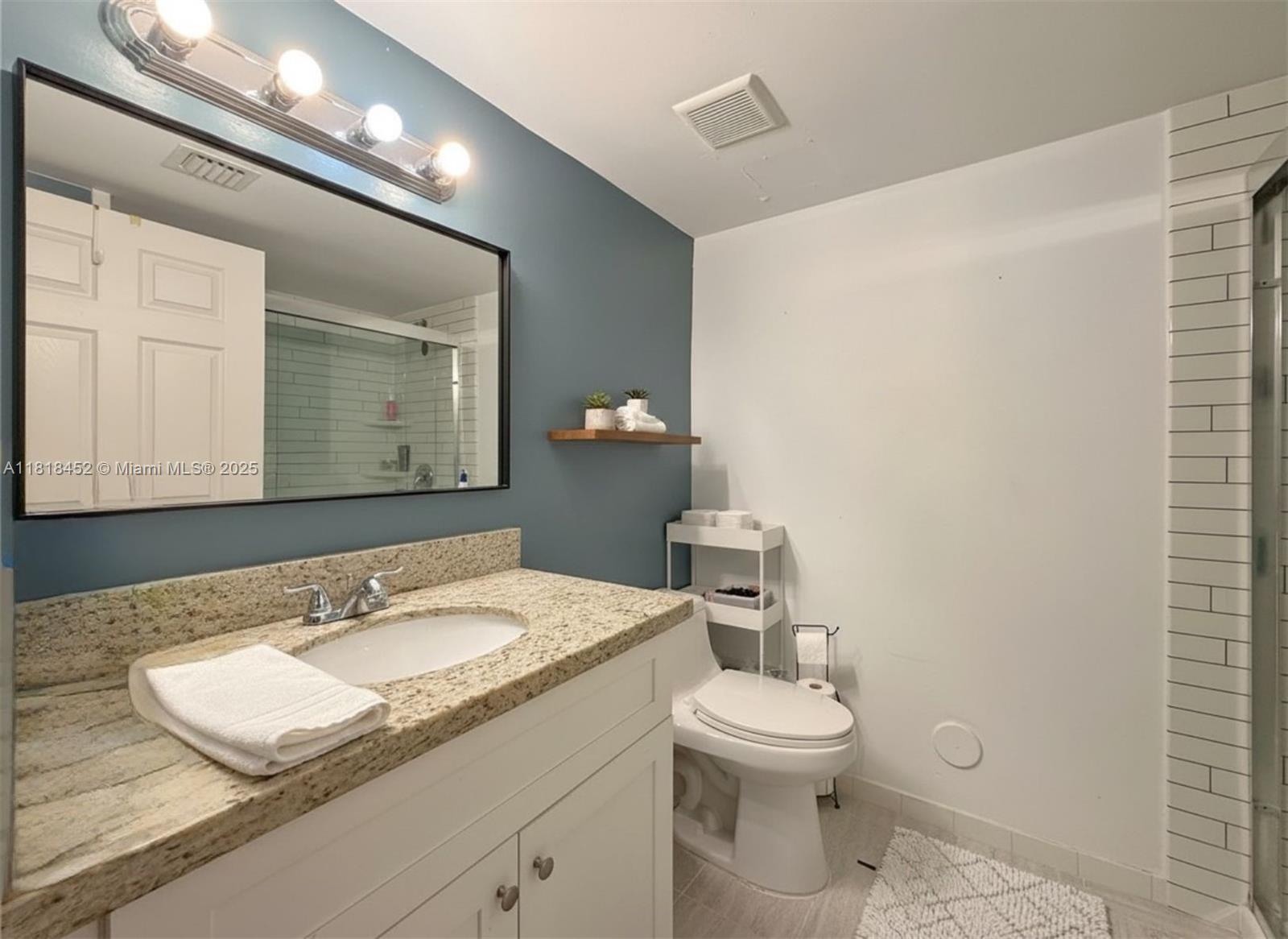 22901 Southwest 88th Place, Unit 101 Cutler Bay, FL 33190 - Photo 9 of 16 a bathroom with a granite countertop sink mirror and a toilet
